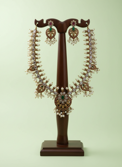 Pair of ornate earrings on a wooden stand against a light green background