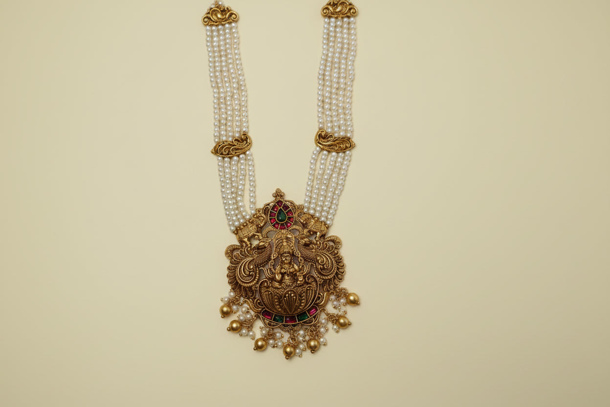 Decorative gold necklace with pearls and gemstones on a white background