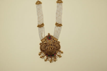 Decorative gold necklace with pearls and gemstones on a white background