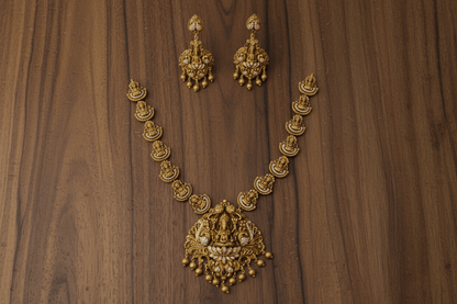 Lakshmi-peacock pendant set in antique gold finish, featuring white stone inlay and gold bead hangings.