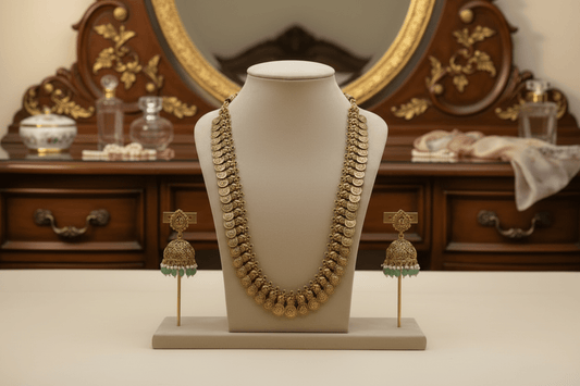 Antique gold long coin necklace with a coin design, paired with matching jhumka earrings featuring emerald green bead drops