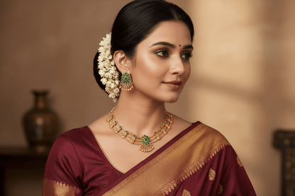 Floral Choker and earring set in antique gold finish, featuring green stone clusters and intricate gold detailing.