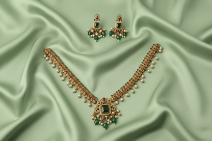 antique gold necklace with a statement emerald pendant, pearl clusters & green bead drops
