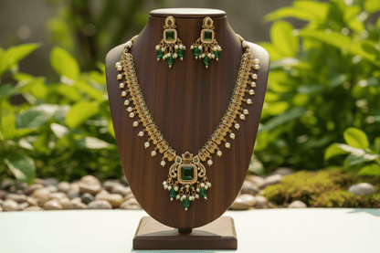 antique gold necklace with a statement emerald pendant, pearl clusters & green bead drops