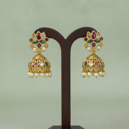 This gold-toned necklace and earring set features pink and green lotus motifs enhanced by delicate pearl hangings.