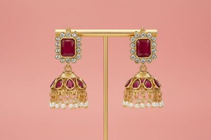 Choker with a central deity figure, framed by intricate motifs, ruby-red stones, shimmering crystals, and pearl danglings.
