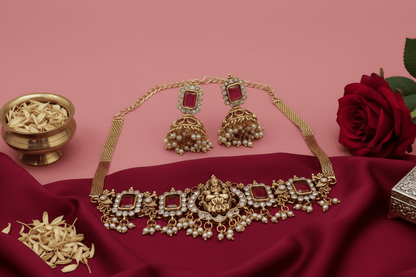Choker with a central deity figure, framed by intricate motifs, ruby-red stones, shimmering crystals, and pearl danglings.