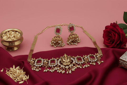 Choker with a central deity figure, framed by intricate motifs, ruby-red stones, shimmering crystals, and pearl danglings.